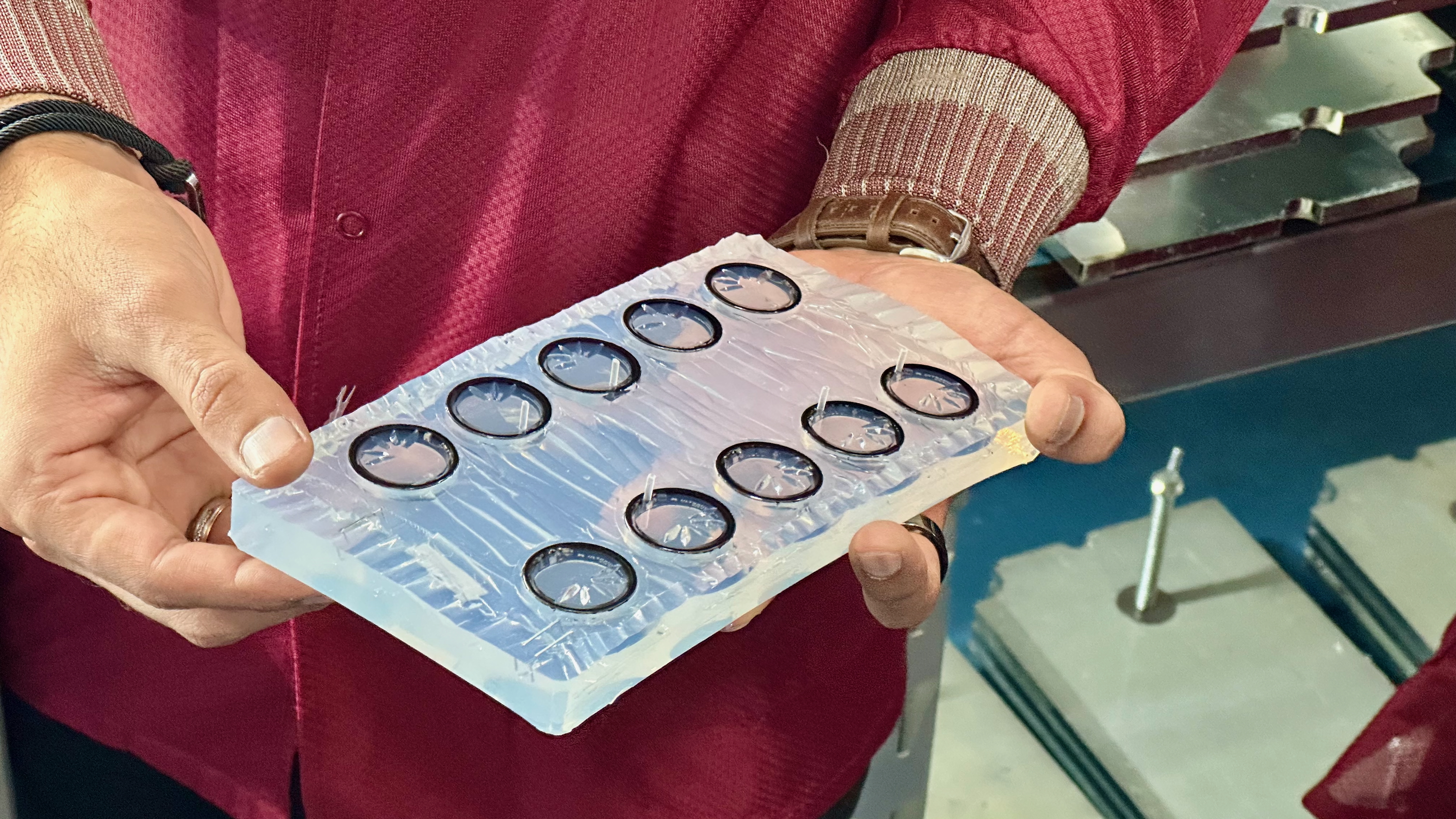 A silicone mold containing 12 Ultrahuman Ring Airs being injected with resin.
