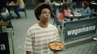 Man standing in street with ramen noodles