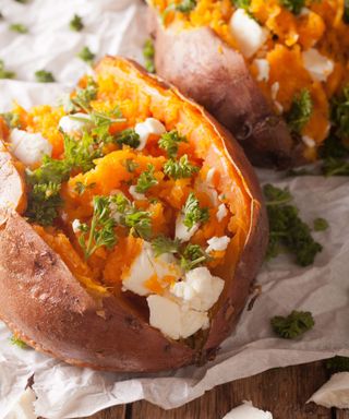 Two sweet potatoes topped with feta and parsley