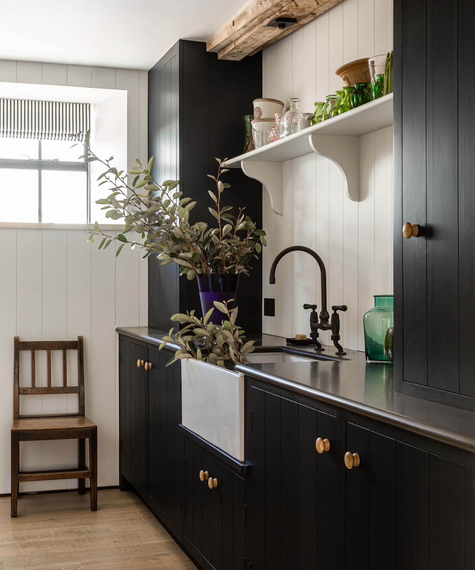 A utility room with black cabinetry and white walls in a 19th century Dorset barn conversion.