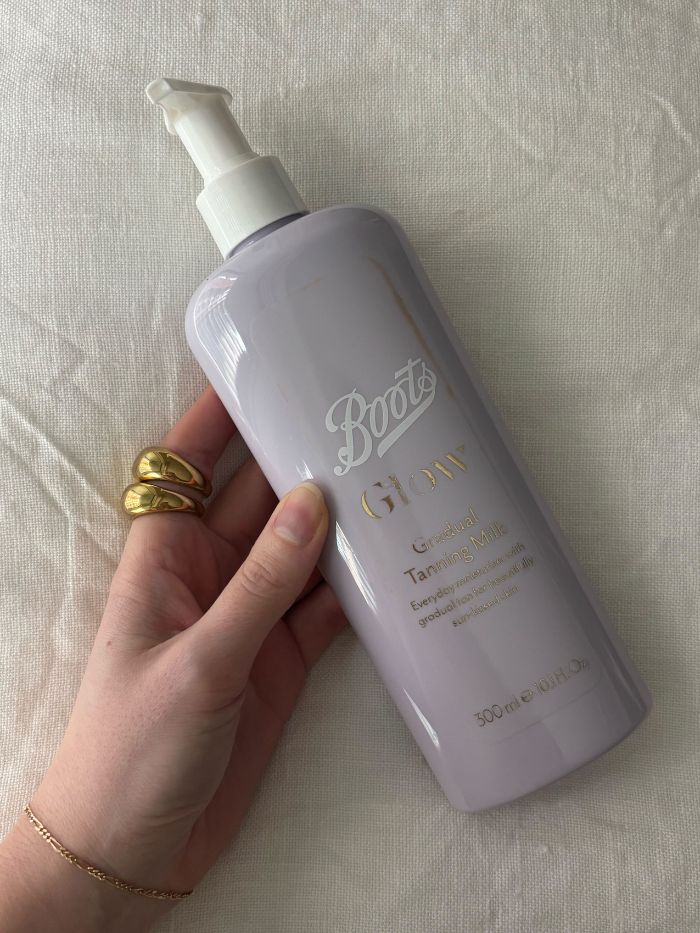 Die stellvertretende Beauty-Redakteurin Grace Lindsay hält die Boots Glow Tanning Milk in der Hand
