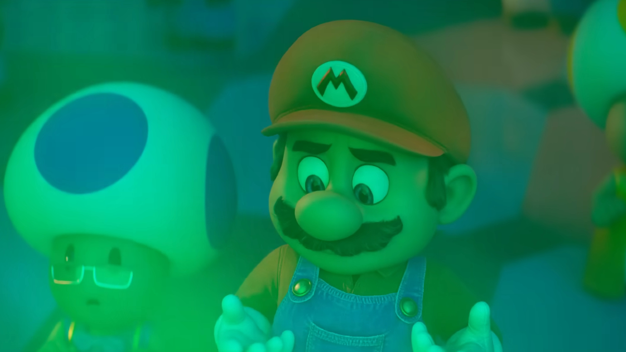 Mario looking at his hands painted in green light in The Super Mario Galaxy Movie