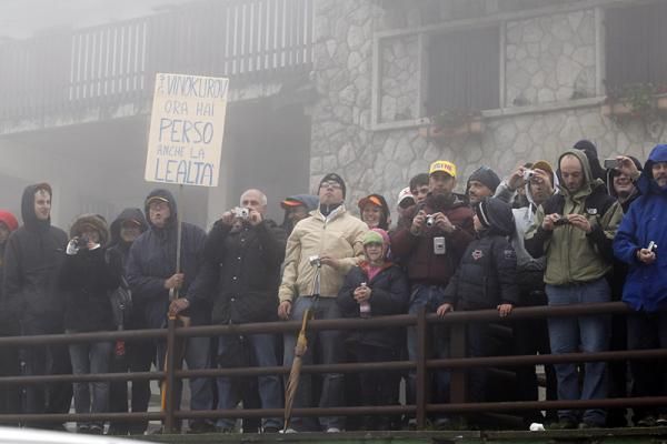 Stone-faced spectators hold a sign saying "Vinokourov now you have lost the loyalty".
