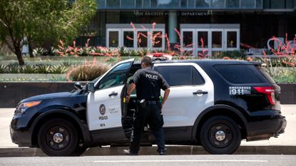 An LAPD officer gets into his patrol car in downtown Los Angeles. 