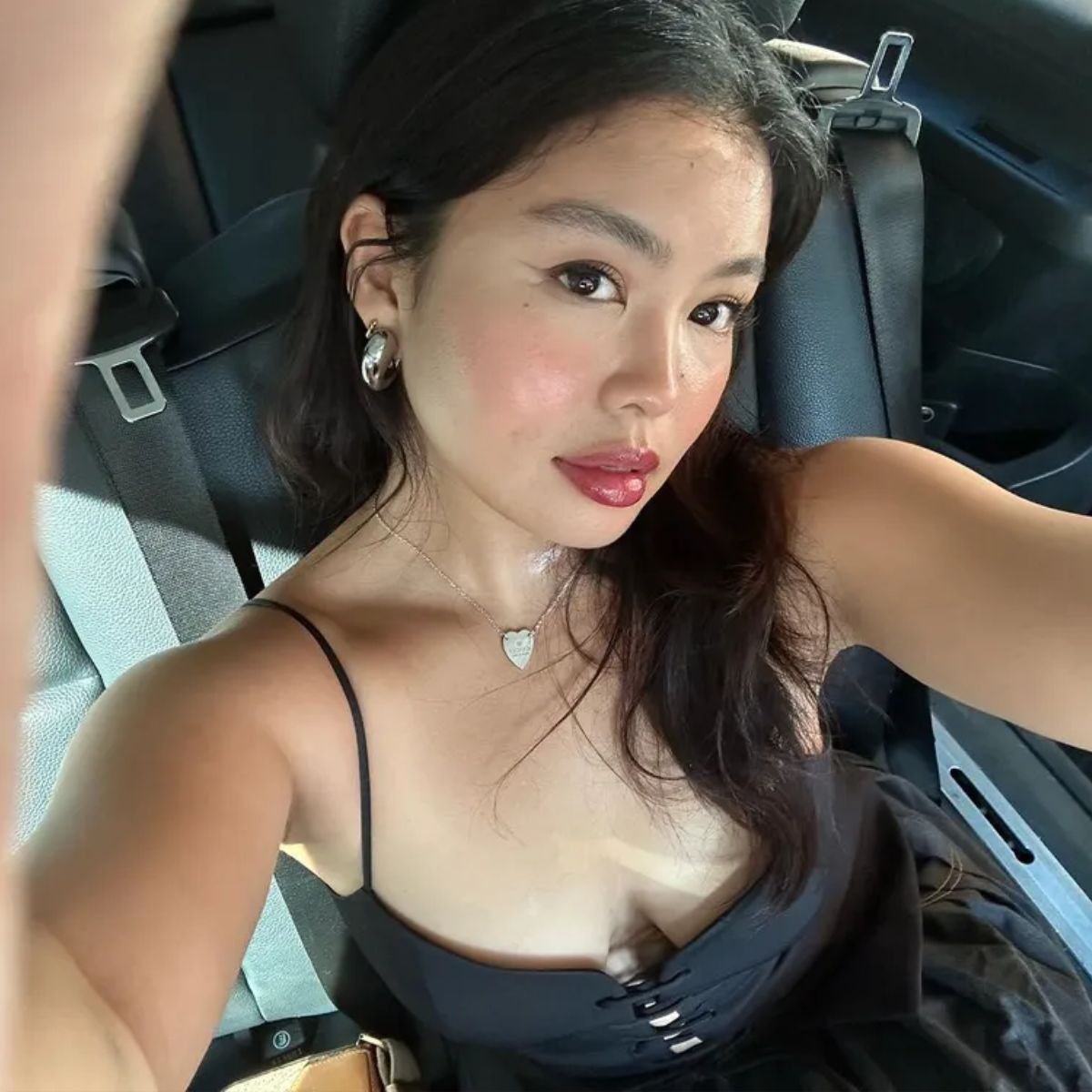 A woman taking a selfie in the car with glowing skin