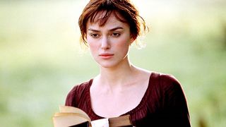 Keira Knightley stands with a book in the film version of Pride and Prejudice