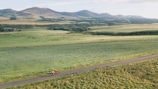 Drone shot of two bike riders with Pentland Hills in distance