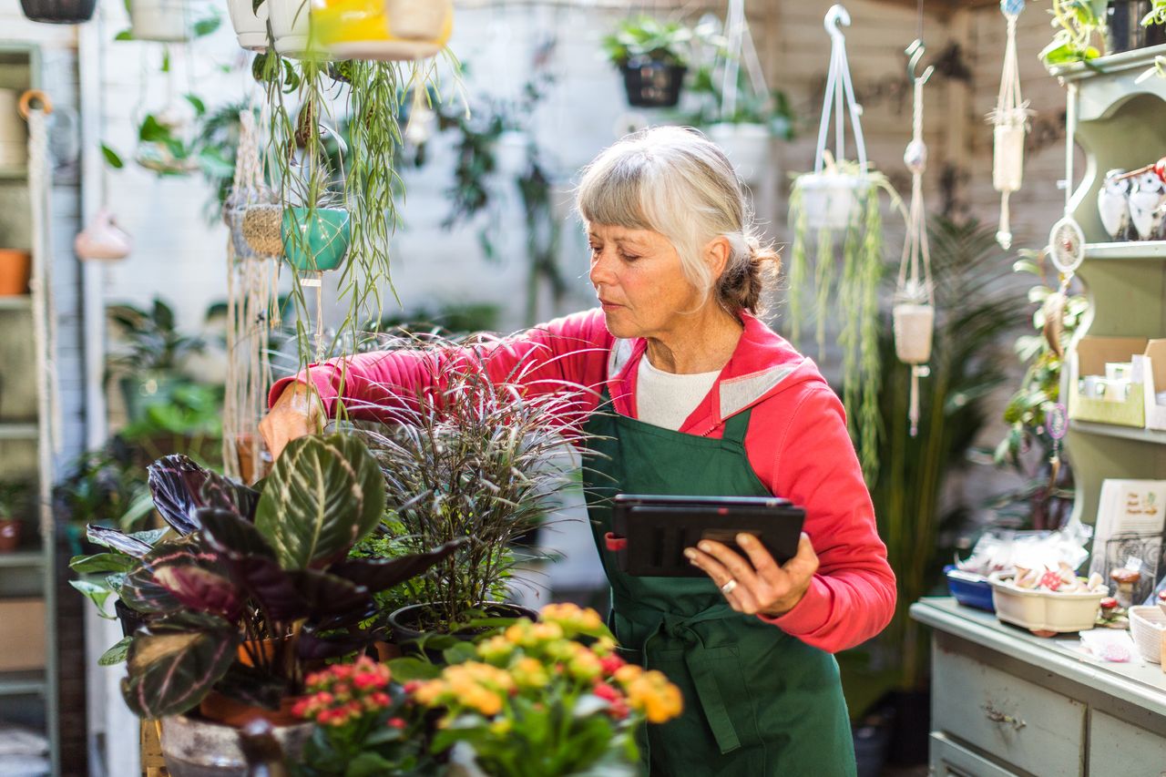 Older woman working in a garden shop