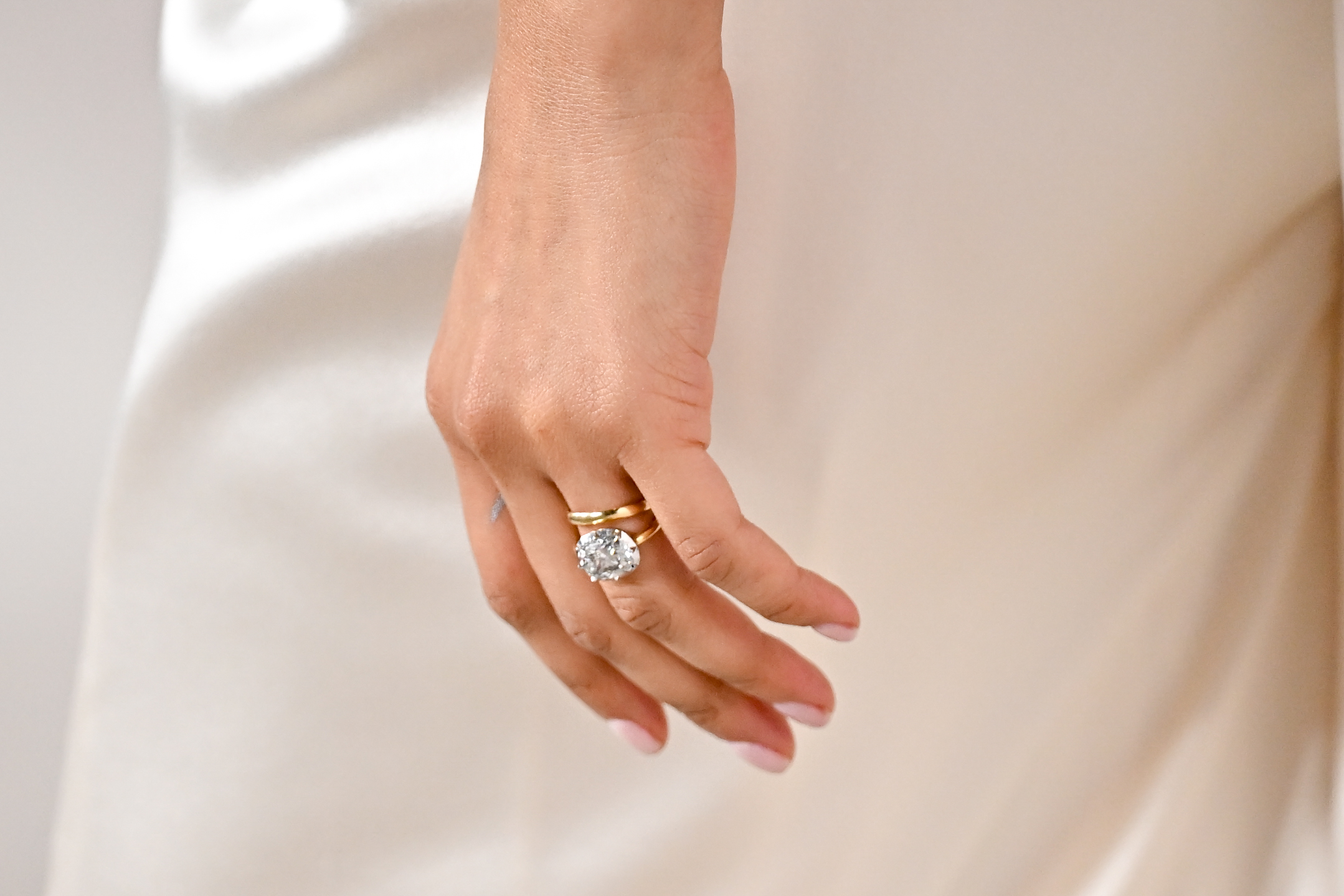 Zendaya wearing white for the drama. This picture is a close up of a diamond on her ring finger.