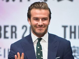 David Beckham in a blue suit and green tie as he helps promote Las Vegas Sands resorts at a press conference in China