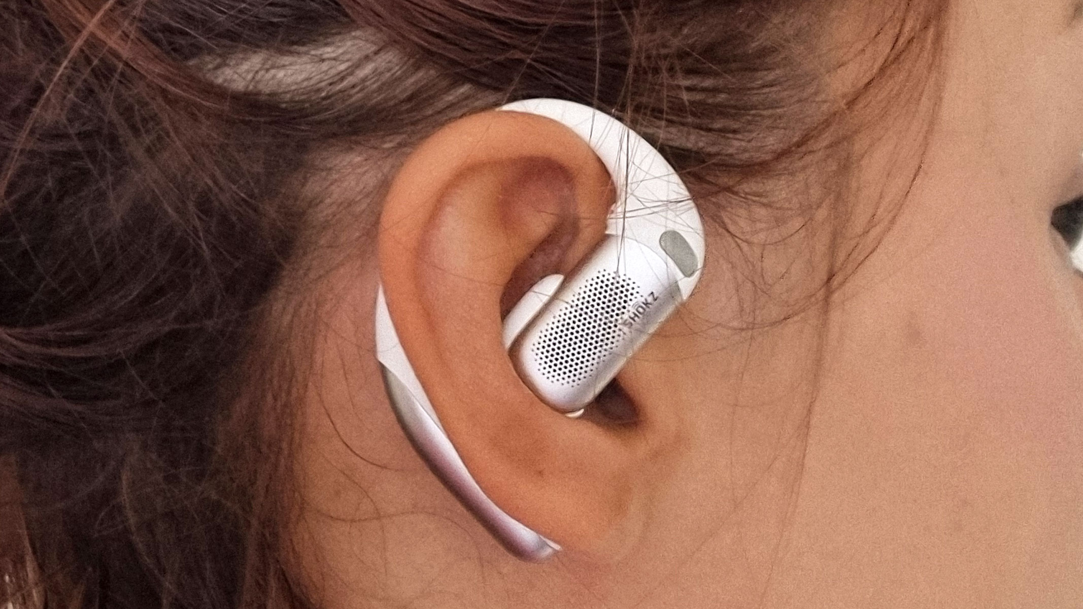 A close-up picture of our reviewer wearing the Shokz OpenFit Pro earbuds
