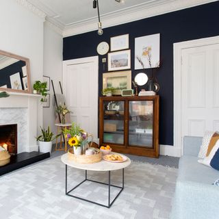 living area with blue wall and white door and fireplace and coffee