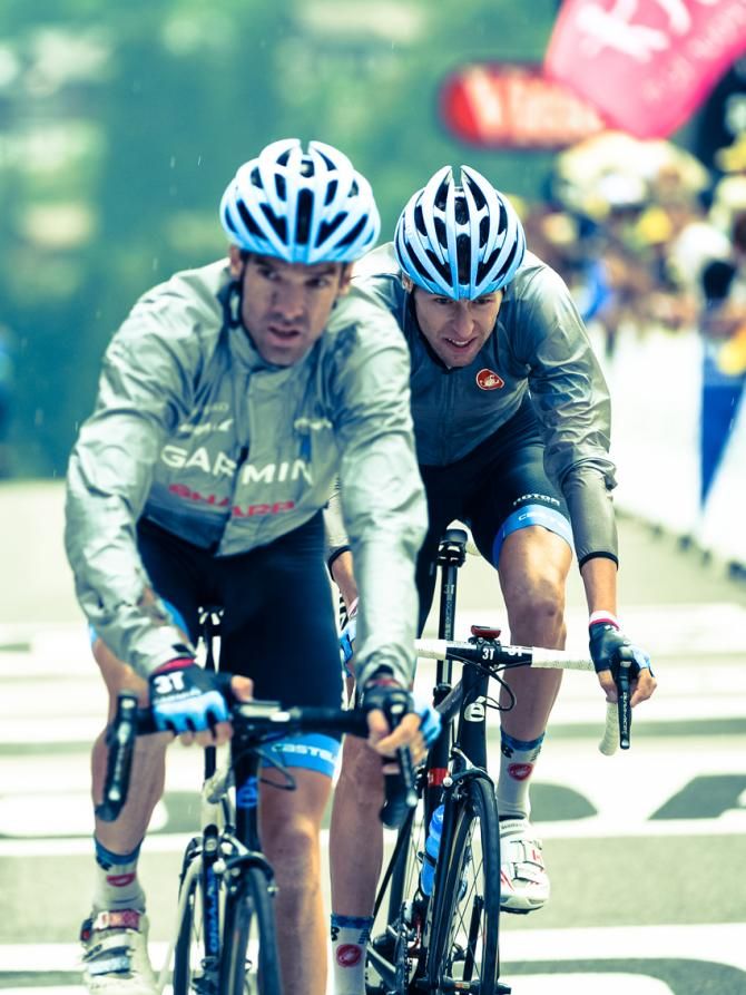 The rain starts to fall on the finish line in La Grand Bornand as Ryder Hesjedal and David Millar arrive at the finish.