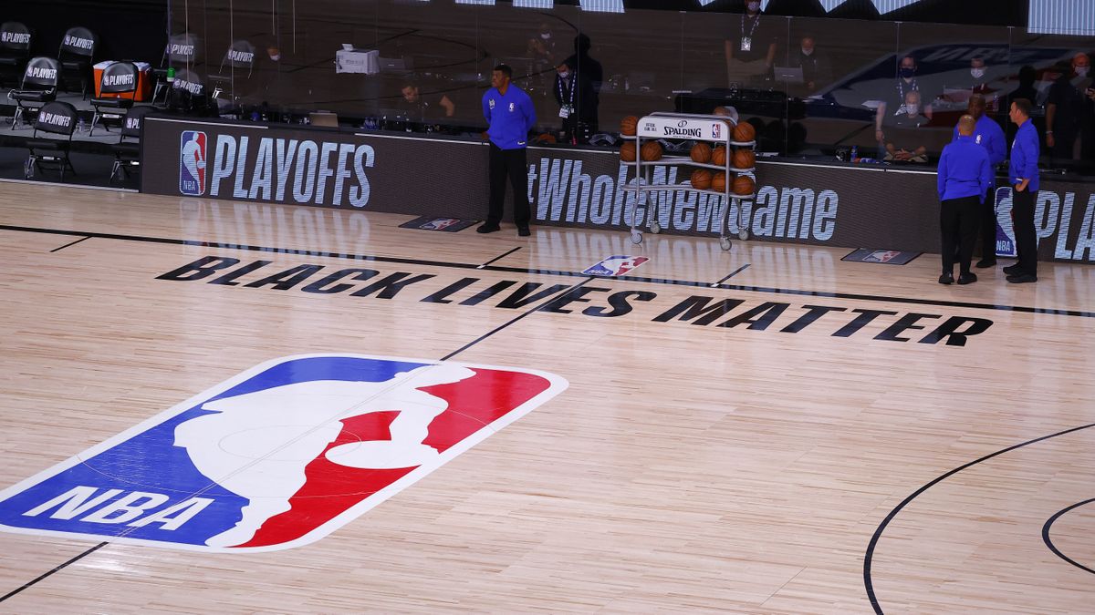 Referees stand on an empty court after the Milwaukee Bucks refused to play Wednesday in Orlando.