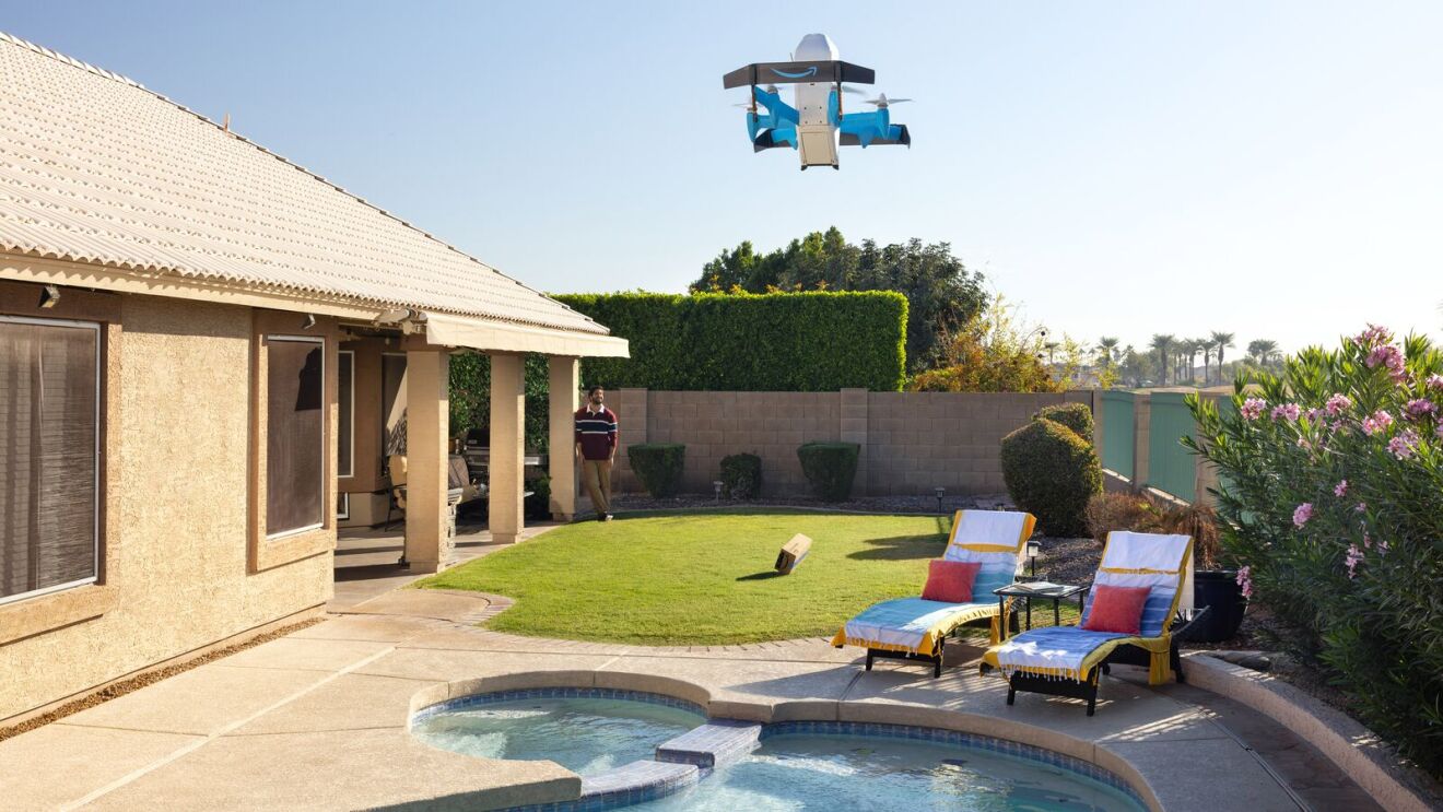 Image of Amazon's MK30 delivery drone dropping a cushioned Amazon parcel from 13 feet up onto a garden lawn.