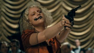 Jessie Buckley holding a gun as The Bride in Warner Bros. Pictures THE BRIDE! A Warner Bros. Pictures release.