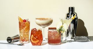 An array of mocktails with a mocktail making kit in front of a white background.