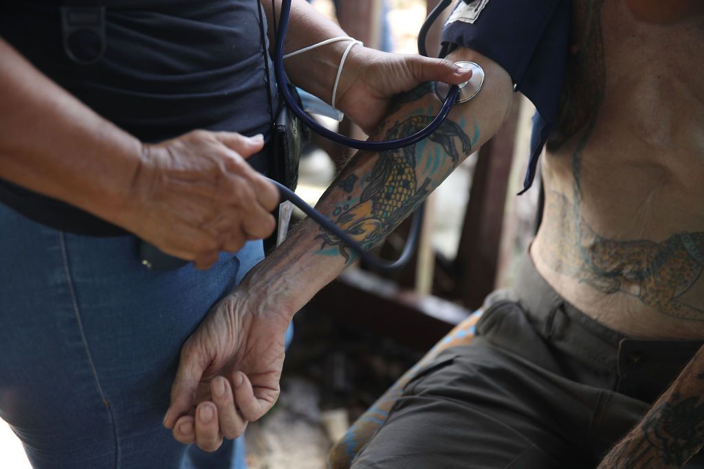 A medic checks on Kirk Thompson as U.S. Army 1st Special Force Command delivered food and water to him after he had not received any aid in the wake of the devastation left across the island 