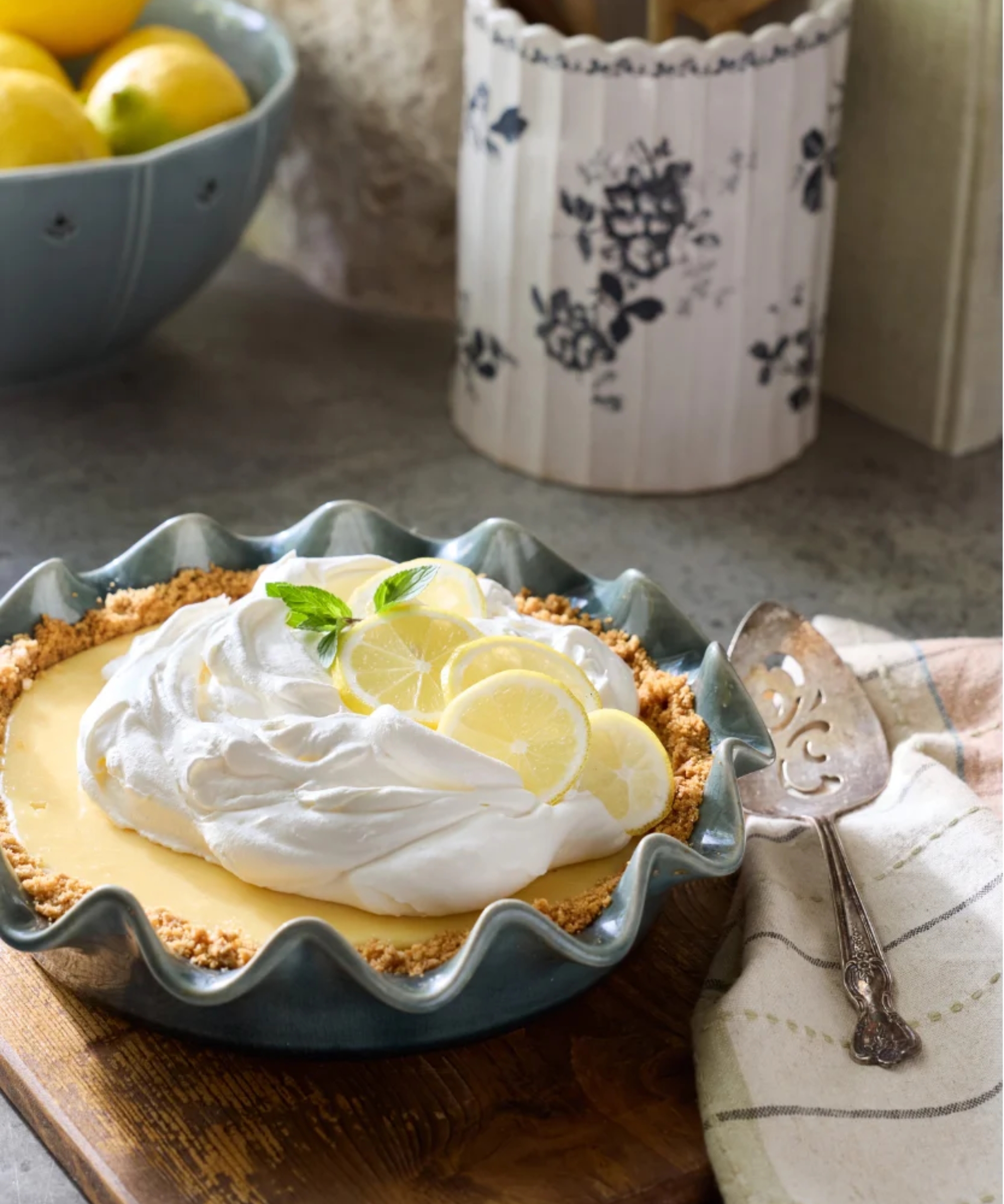 A blue scalloped pie dish with lemon cream pie