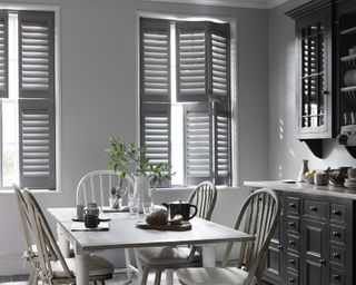 A grey dining room idea with grey window shutters