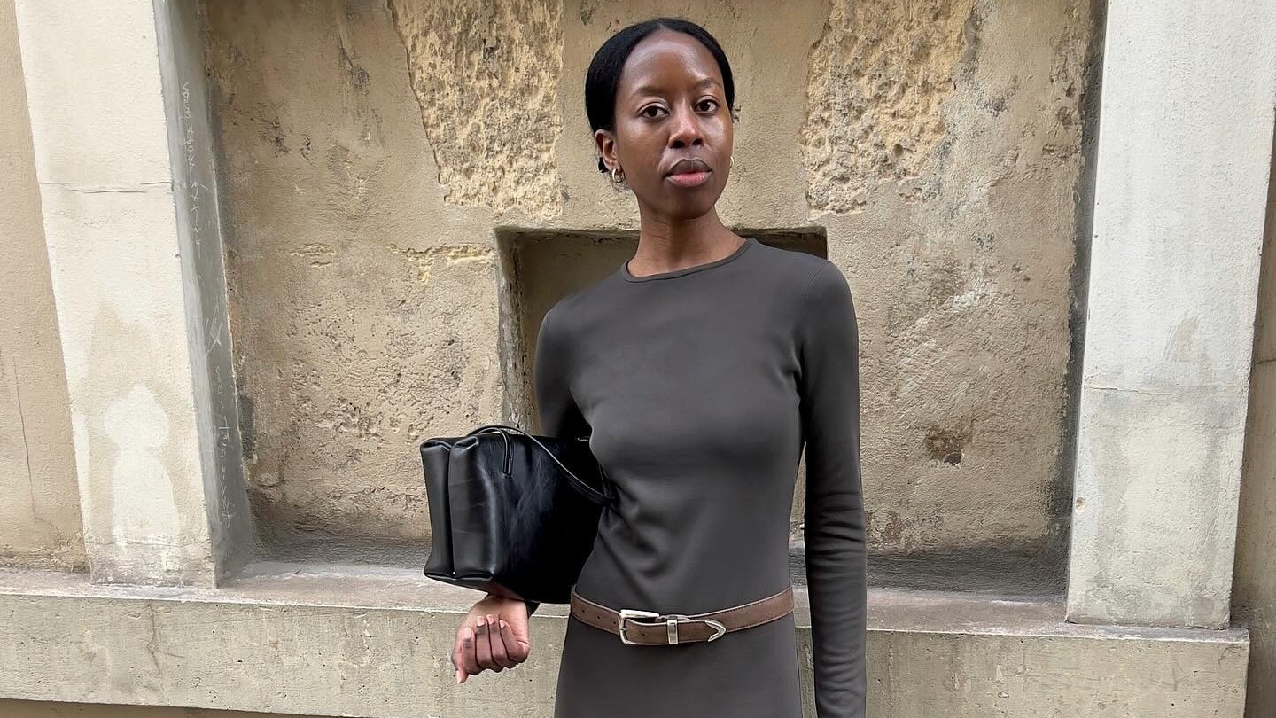 Woman wears a long sleeve maxi dress, pointy heeled ankle boots and a brown Western-style belt