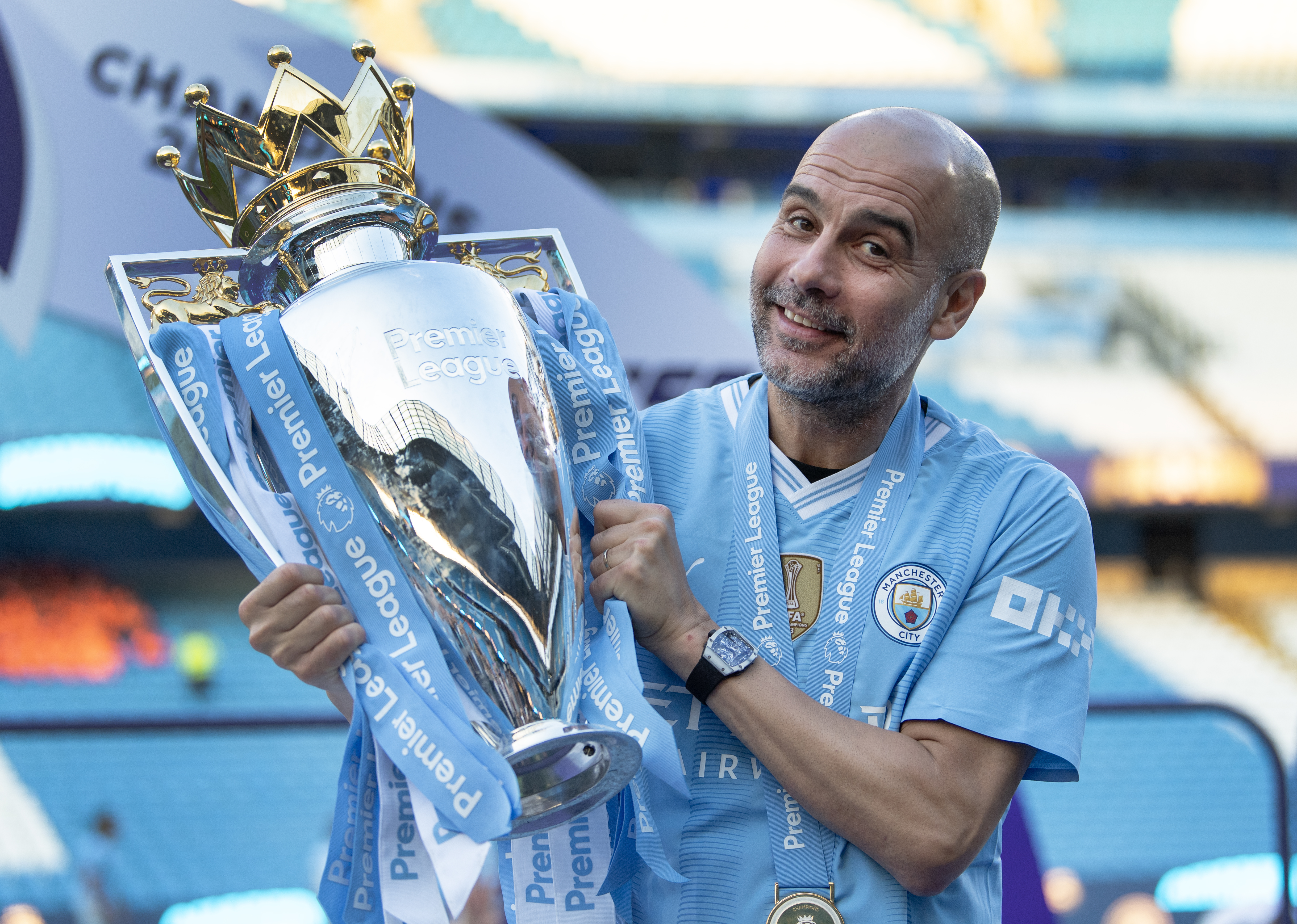 Manchester City manager Pep Guardiola poses with the Premier League trophy in May 2024.