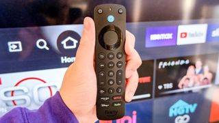 The Alexa Voice Remote Pro in hand in front of a TV
