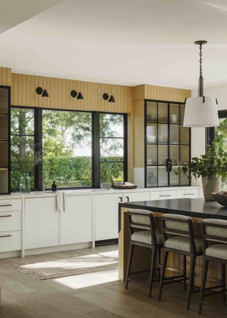 A kitchen extension with an island and wood floors. Bar stools are placed next to the kitchen island.