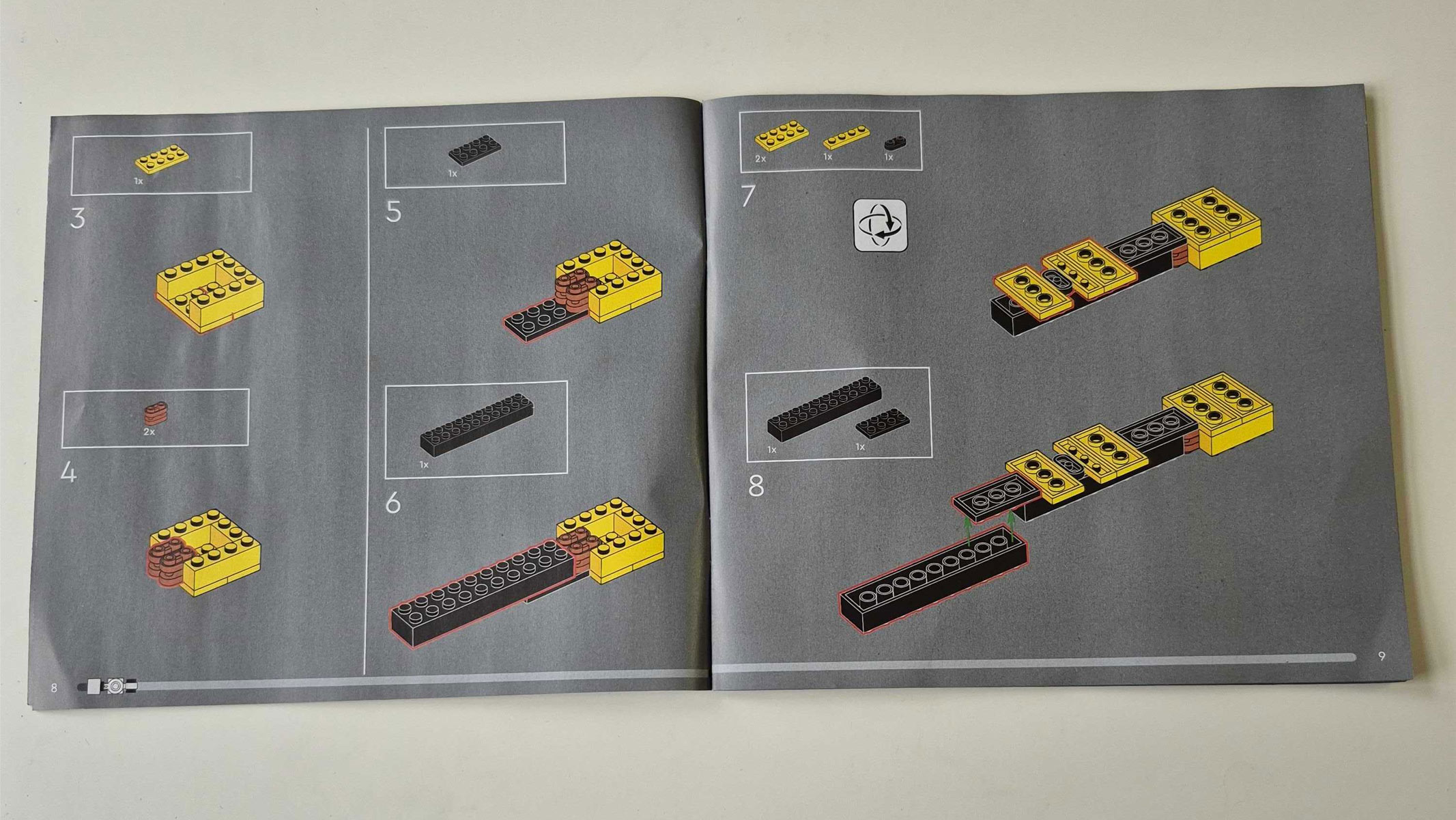 Two pages of a booklet giving instructions on how to build part of a Lego set, using images.