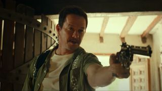 Mark Wahlberg aiming a gun, and sporting the Sully Stache, in Uncharted.