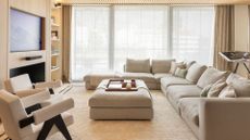 A beige sofa in a living room with beige accent chairs 