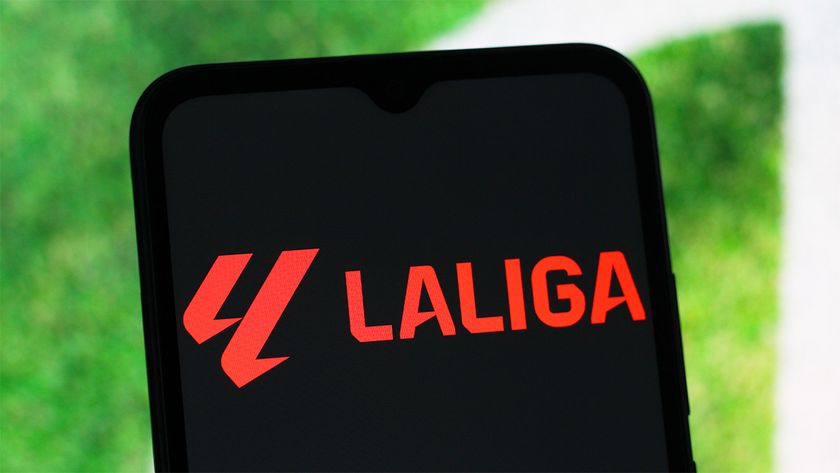 smartphone displaying LaLiga logo in red text in front of part of a football pitch