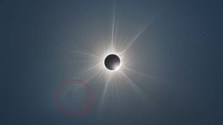 Solar eclipse image with the sun's corona glowing behind like wispy smoke
