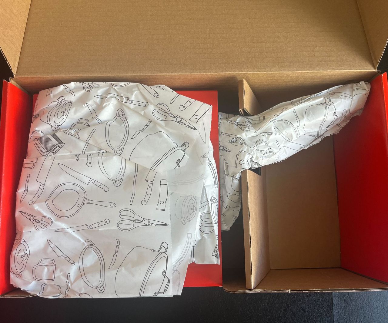 A pan covered in tissue paper in a cardboard box.