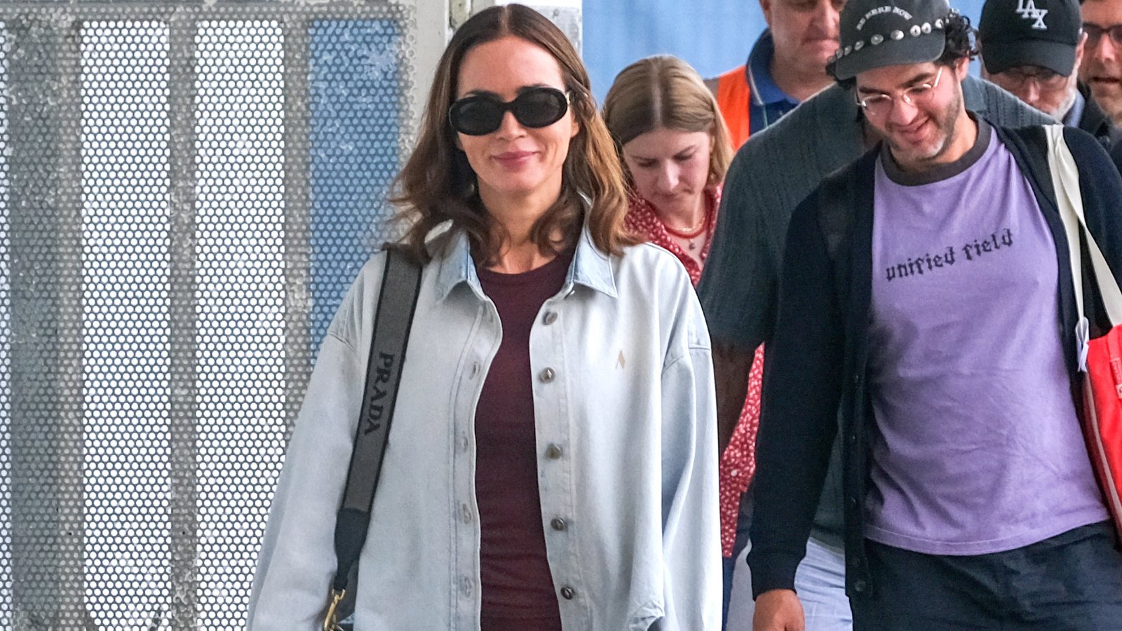 Emily Blunt wearing a red dress and shacket