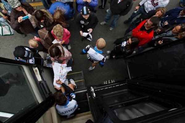 Christian Vande Velde (Garmin-Cervelo) keeps his young fans happy while Andrew Talansky heads for his bike.