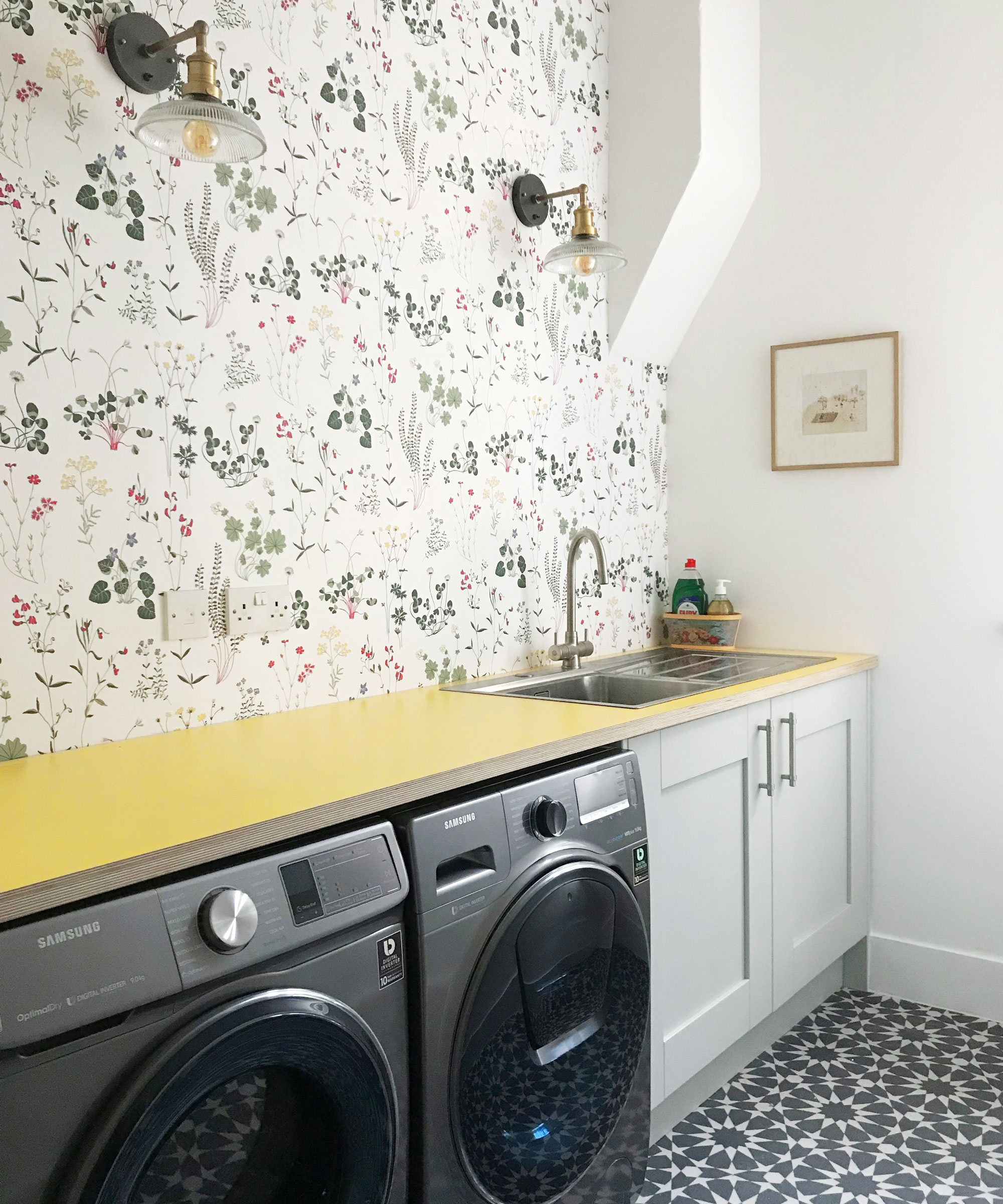 pretty utility room with yellow worktops and floral wallpaper