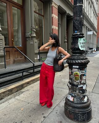 Woman wearing red pants and slippers in NYC.