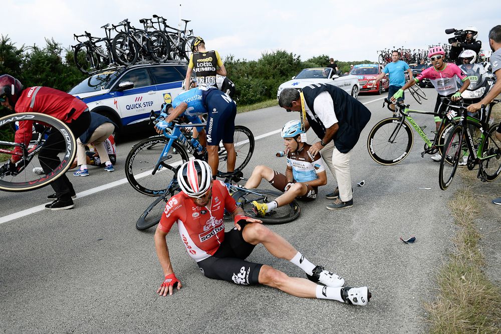 Axel Domont (AG2R) and Tomasz Marczynski (Lotto Soudal) grimace after being caught in a massive pack fall in the last kilometers of the fourth stage of the 105th edition of the Tour de France