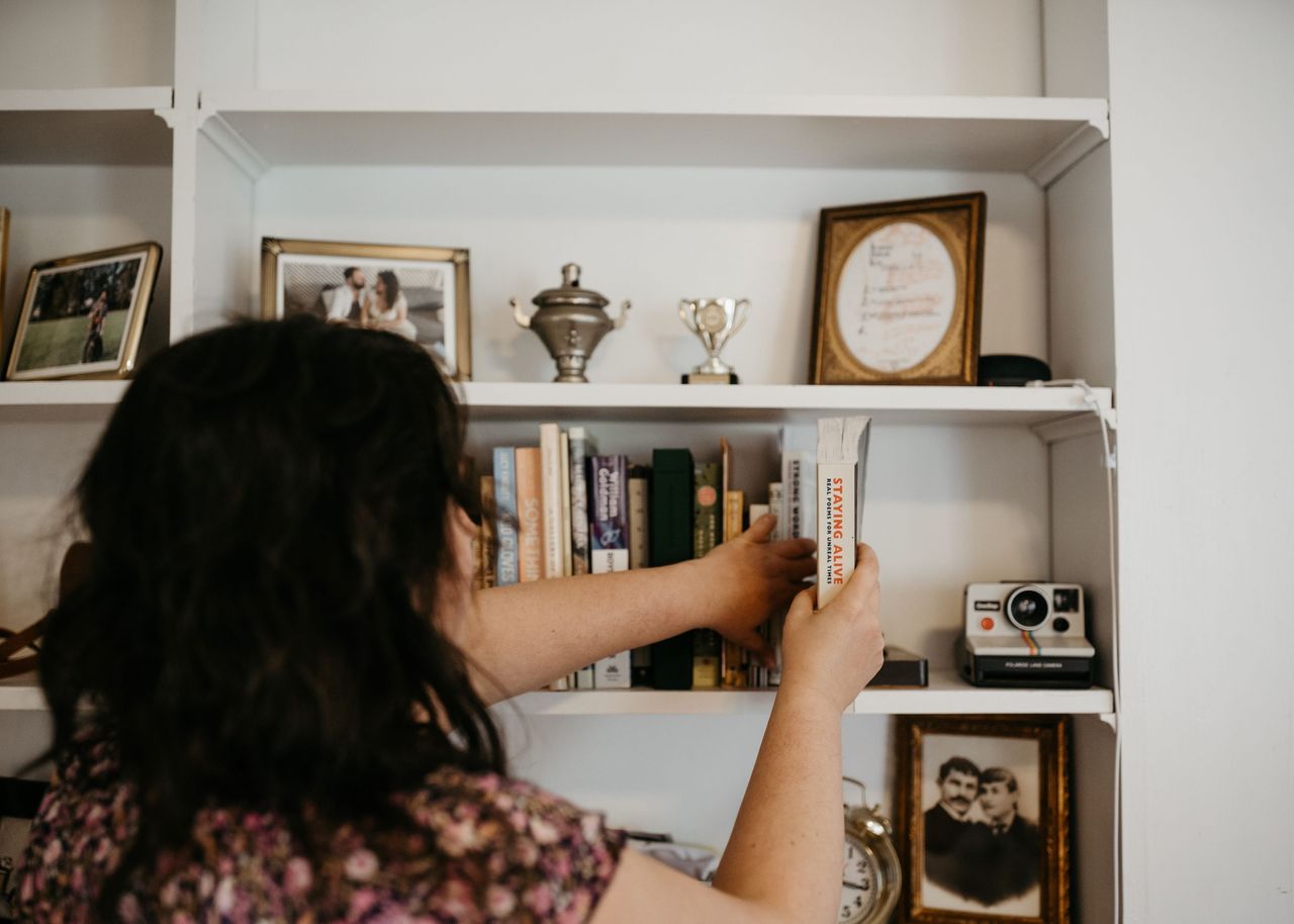 Person rearranging bookshelf