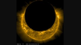 The sun (fiery yellow circle) is being mostly blocked by the moon (black circle in front).