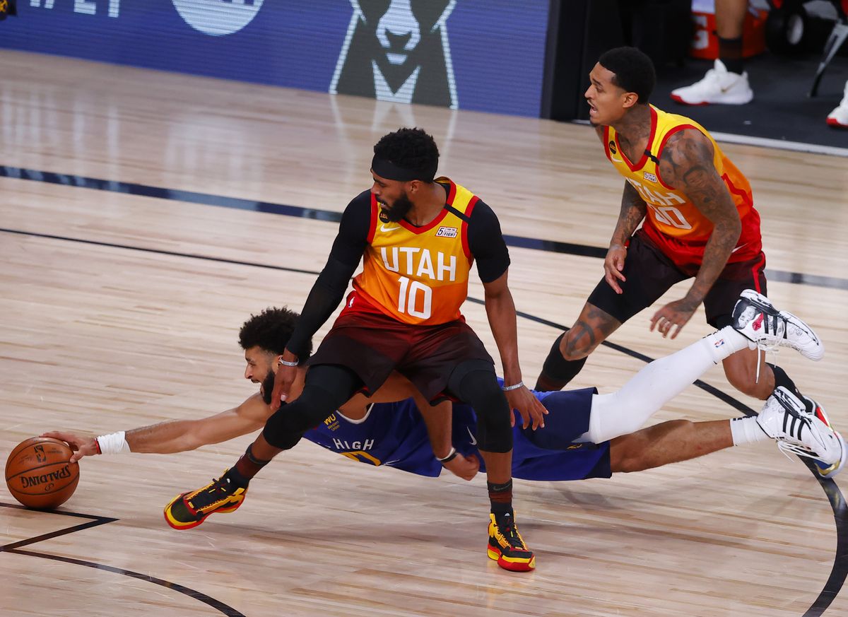 Jamal Murray #27 of the Denver Nuggets dives to grab a loose ball against Mike Conley #10 and Jordan Clarkson #00 of the Utah Jazz during the fourth quarter in Game Six of the Western Conference First Round during the 2020 NBA Playoffs at AdventHealth Arena at ESPN Wide World Of Sports Complex on Aug. 30, 2020 in Lake Buena Vista, Florida.