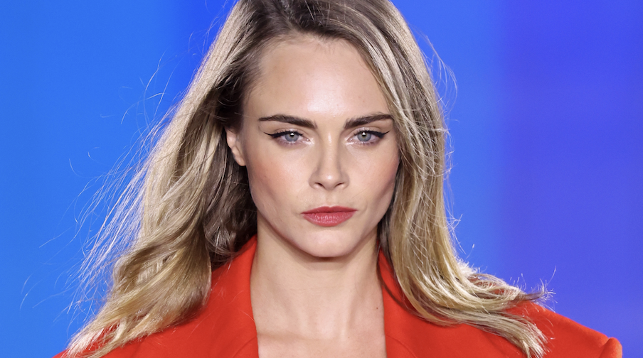  Cara Delevingne walks the runway during &quot;Le Défilé L&#039;Oréal Paris – Walk Your Worth&quot; Womenswear Spring-Summer 2025 show as part of Paris Fashion Week on September 23, 2024 in Paris, France wearing a red topcoat and underwear