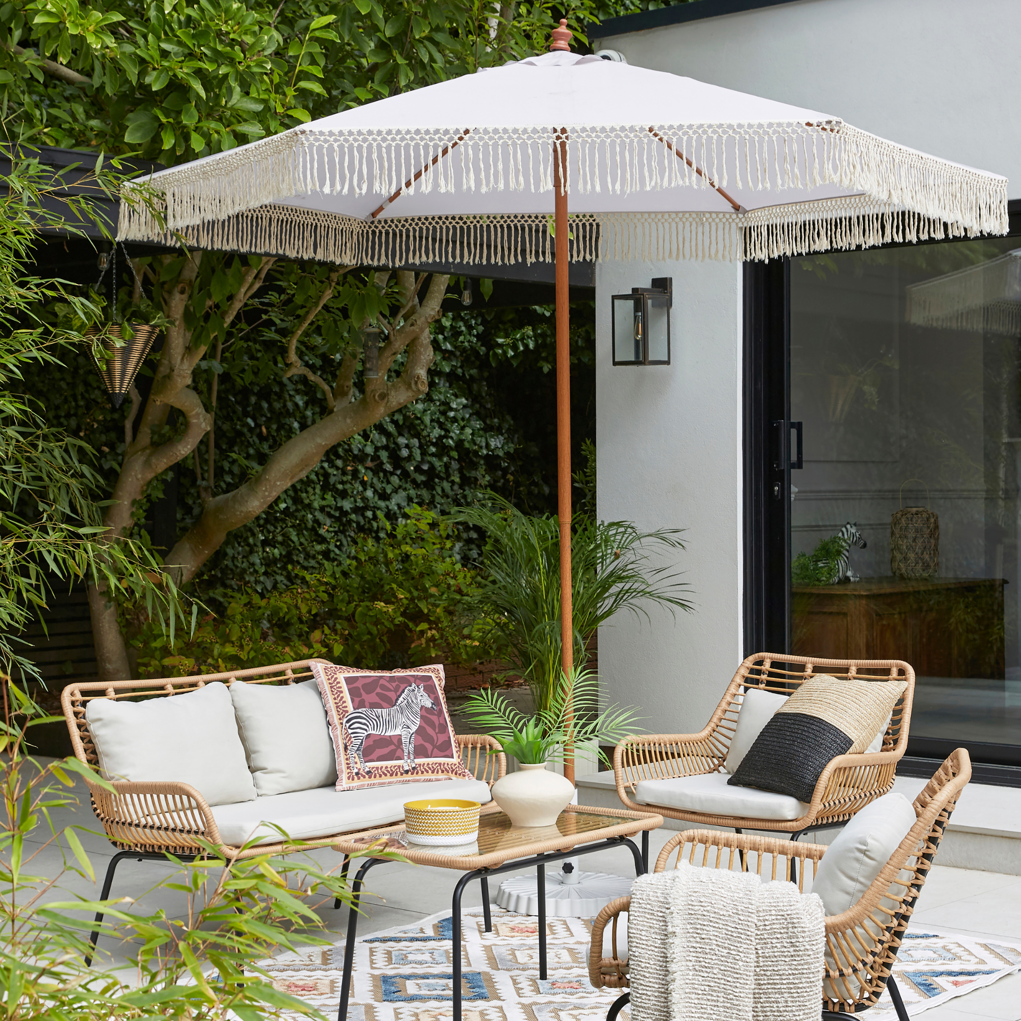 Dunelm Singapore conversation set and parasol on a patio.