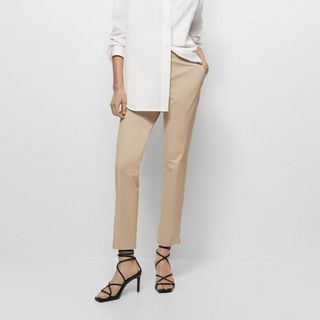 Massimo Dutti beige split hem chino trousers on a model, paired with a white shirt