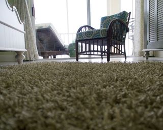 Low angle view of room looking across a shag rug on a tile floor with furniture