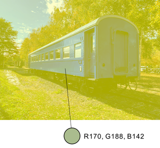 Image of a train on tracks in a grassy area with trees. There is a yellow filter over everything.