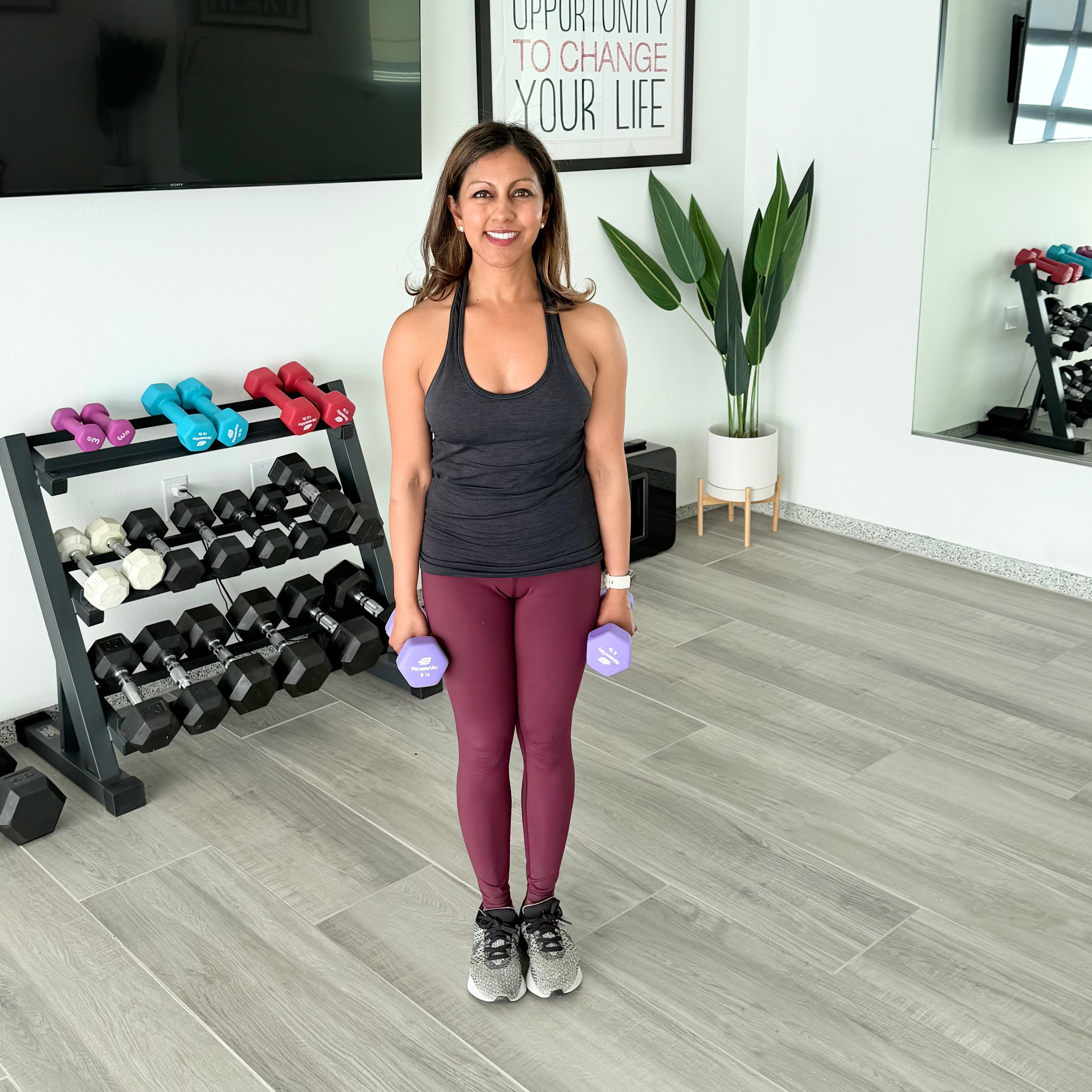 Reena Vokoun stands with a pair of dumbbells in her hands.