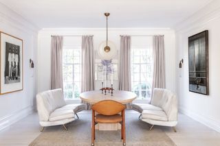 white dining room with white sofas by Brigette Romanek
