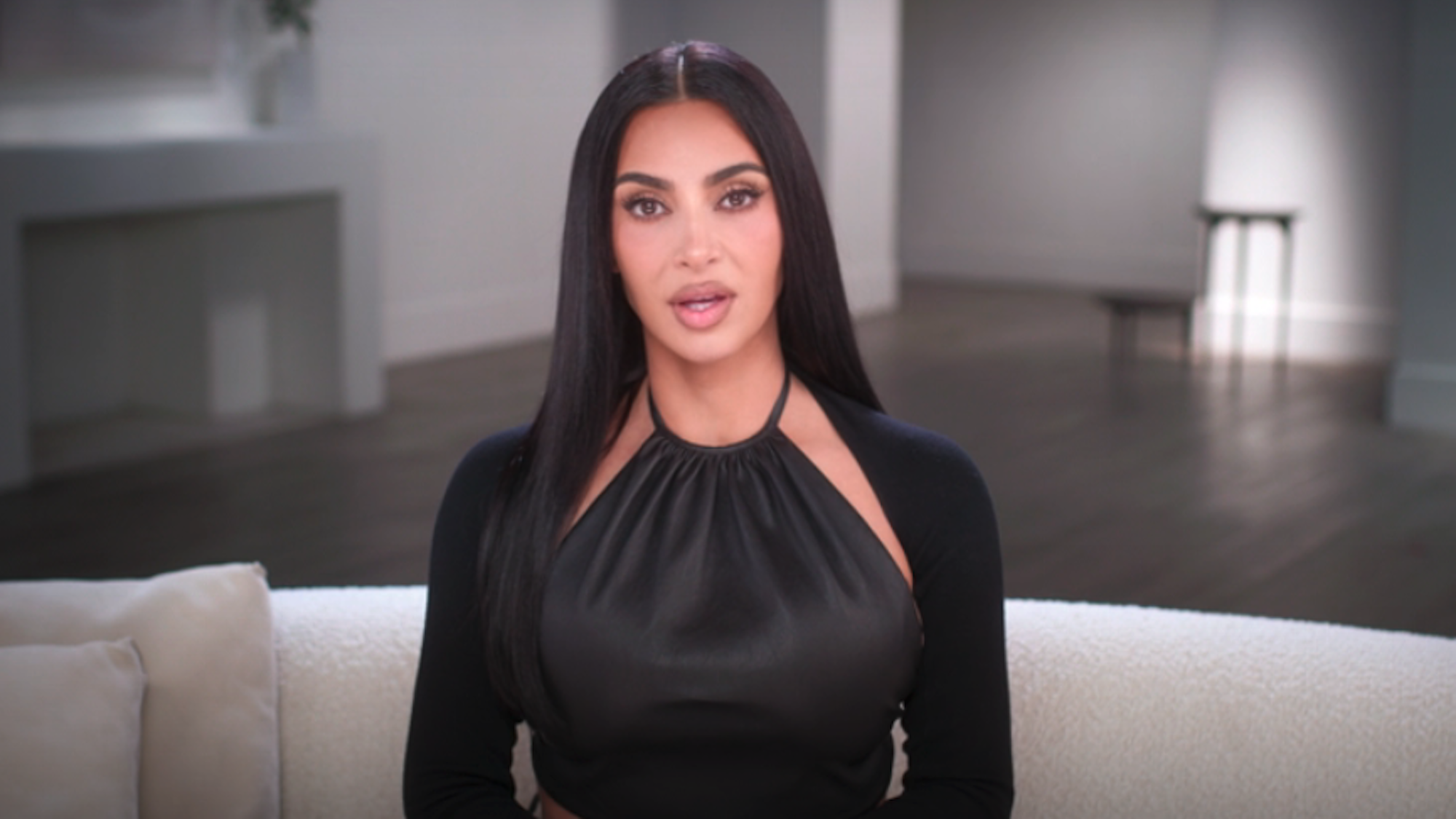 Kim Kardashain in a black halter top being interviewed in The Kardashians Season 8